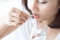 Closeup woman hand holding pills and glass of water, health care and medical concept, selective focus Royalty Free Stock Photo
