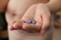 Closeup of woman hand holding pills or vitamins for pregnant females showing her bare belly standing in home interior taking care Royalty Free Stock Photo