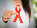 Closeup woman hand holding red ribbon HIV Royalty Free Stock Photo