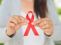 Closeup woman hand holding red ribbon HIV Royalty Free Stock Photo