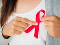 Closeup woman hand holding red ribbon HIV Royalty Free Stock Photo