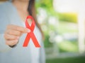 Closeup woman hand holding red ribbon HIV Royalty Free Stock Photo