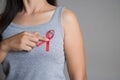 Closeup woman hand holding red ribbon HIV, world AIDS day awareness ribbon. Healthcare and medicine concept Royalty Free Stock Photo