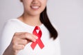 Closeup woman hand holding red ribbon HIV, world AIDS day awareness ribbon. Healthcare and medicine concept Royalty Free Stock Photo