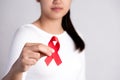 Closeup woman hand holding red ribbon HIV, world AIDS day awareness ribbon. Healthcare and medicine concept Royalty Free Stock Photo