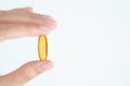 Closeup woman hand holding vitamins- supplements capsules- on white background.