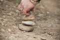 Woman hand making stone balance in the sand Royalty Free Stock Photo