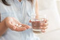 Closeup woman hand with pills medicine tablets and glass Royalty Free Stock Photo