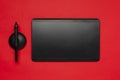 Top view of black graphics tablet on the red surface