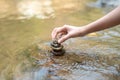 Closeup woman hand to doing Stone stacked in water river stream Royalty Free Stock Photo