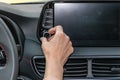 Closeup of woman hand, turning button on car radio for listening to music. Modern car interior Royalty Free Stock Photo