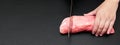 Closeup of the woman hands of a butcher cutting slices of raw meat off a large loin on black background with copy space