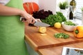 Closeup of woman hands cooking vegetables salad in kitchen. Housewife cuts lemon. Healthy meal and vegetarian concept. Royalty Free Stock Photo