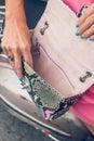 Closeup woman hands with fashion luxury snakeskin python handbag on a retro motorbike background. Outdoors, Bali island.