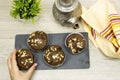 Closeup woman hands holding a blackboard chocolate nuts muffins, arabic teapot on wood table Royalty Free Stock Photo