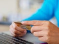 Closeup woman hands holding a credit card and using laptop Royalty Free Stock Photo