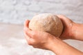 Closeup woman hands holding kneaded dough from rye flour over marble countertop in bright kitchen. process of baking health bread Royalty Free Stock Photo