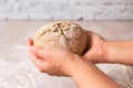 Closeup woman hands holding kneaded dough from rye flour over marble countertop in bright kitchen. process of baking health bread Royalty Free Stock Photo