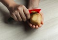 Closeup of woman hands peeling a potato,  on white background Royalty Free Stock Photo