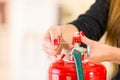 Closeup woman hands with red nailpolish showing how to operate fire extinguisher Royalty Free Stock Photo