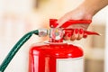 Closeup woman hands with red nailpolish showing how to operate fire extinguisher Royalty Free Stock Photo