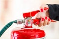 Closeup woman hands with red nailpolish showing how to operate fire extinguisher Royalty Free Stock Photo