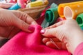 Closeup of woman hands sewing pink hamdmade toy