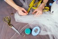 Closeup woman hands tailor wedding dressmaker seamstress sew on the sewing machine on a blue background in the studio