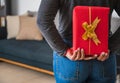 Closeup of a woman hiding a red gift box behind her back Royalty Free Stock Photo