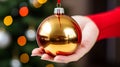 Closeup on woman holding christmas bauble against blurred christmas lights