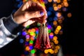 Closeup of a woman holding a Christmas tree decoration isolated on bokeh lights background Royalty Free Stock Photo