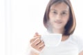 Closeup woman holding a cup of hot coffee with over light from window, selective focus Royalty Free Stock Photo