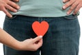 Closeup of woman holding heart over man pants Royalty Free Stock Photo