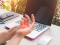 Closeup woman holding her painful hand from using computer