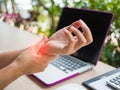 Closeup woman holding her wrist pain from using computer. Royalty Free Stock Photo