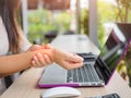 Closeup woman holding her wrist pain from using computer. Royalty Free Stock Photo