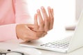 Closeup woman holding her wrist pain from using computer. Royalty Free Stock Photo