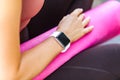 Closeup woman holding pink yoga mat, smartwatch on her hand with black empty display for time or pulse indicator