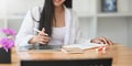 Closeup woman holding a stylus pen while sitting in front her computer tablet and notebook. Royalty Free Stock Photo