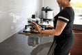 Closeup, A woman holds a tablet looking at the cooking method. A woman cooking lunch By looking at how to cook food from the