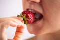 Closeup of a woman mouth eating strawberry. Royalty Free Stock Photo