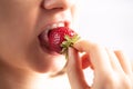 Closeup of a woman mouth eating strawberry. Royalty Free Stock Photo