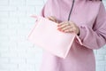 closeup woman in pink clothes hands holding pink toiletry bag for mockup