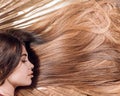 Closeup woman portrait with very long hair, copy space. Woman with beautiful long hair on wooden background. Long hair