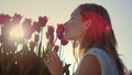 Closeup female touching flower bud. Smiling girl enjoying tulip in sun beams. Royalty Free Stock Photo