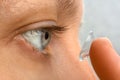 Closeup of woman putting contact lens in her eye Royalty Free Stock Photo