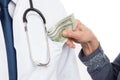 Closeup of woman putting money inside medic coat pocket