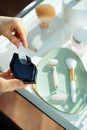 Woman putting out lip mask in living room in sunny day