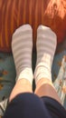 Closeup woman relaxes on sofa in white striped socks