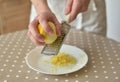 Woman rubbing lemon zest on grater Royalty Free Stock Photo